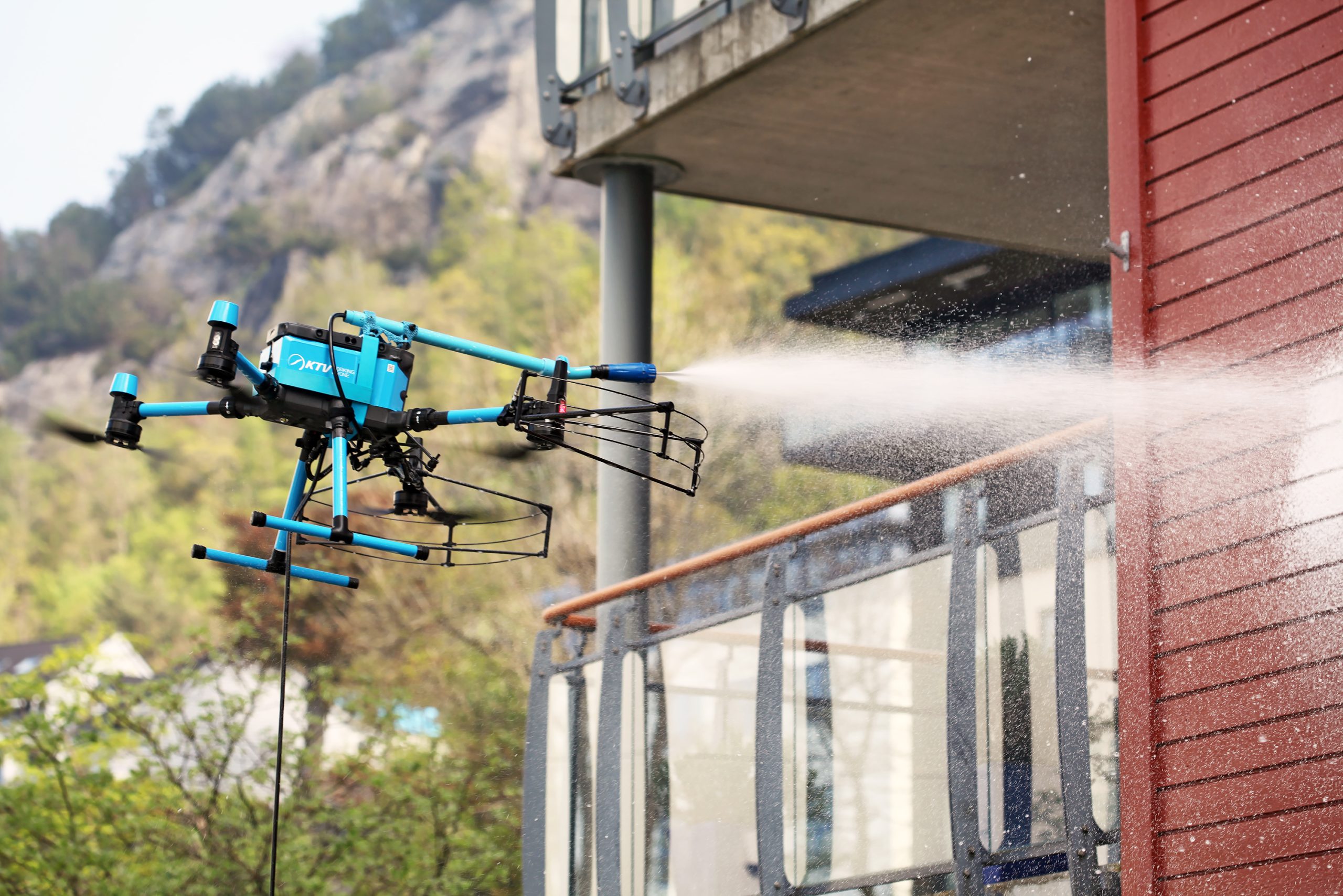 Dron especializado realizando limpieza de fachadas en altura con tecnología profesional